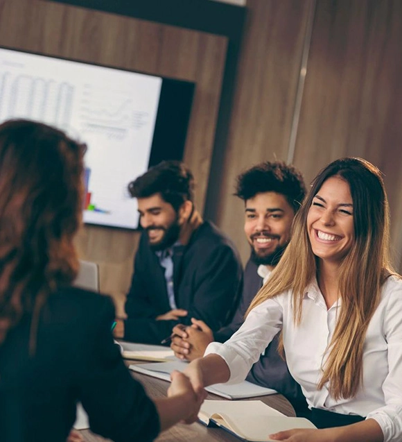 Smiling woman shaking hands in meeting.