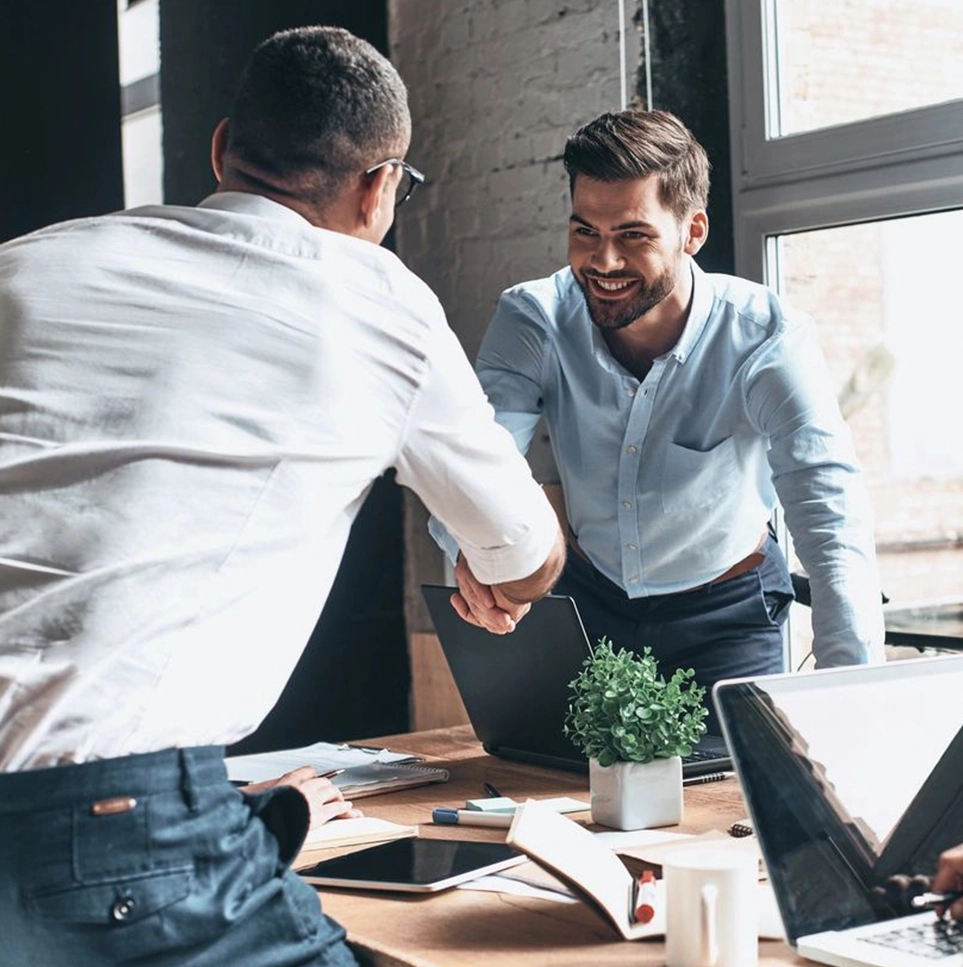 Two businessmen shaking hands in office.